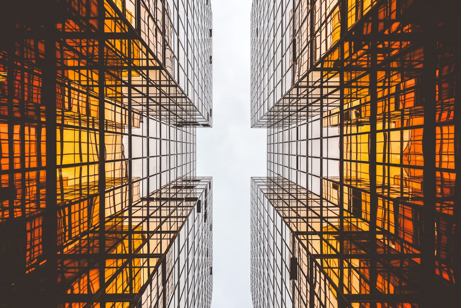 Looking up between tall glass buildings